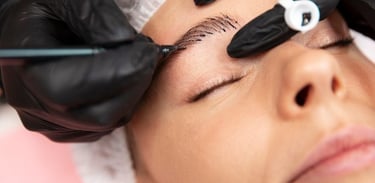 Técnico profesional realizando un procedimiento de microblading de cejas