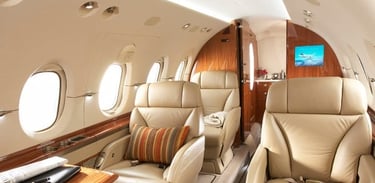 Elegant private jet interior with plush leather seating, wood finishes, and VIP amenities. Ideal for executive travel, busine