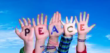 a group of people holding hands up with peace written on their hands