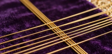 Detail of a ritual being performed: golden threads intertwined on a purple velvet cloth. Soft focus, high-end photography style.