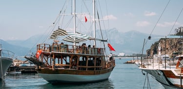 Passeio de barco pirata em Antália, com o barco navegando pelo mar e a cidade ao fundo