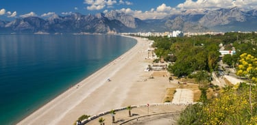 Praia de Koyallti em Antália, com montanhas ao fundo e o mar à frente