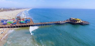 Vista aérea do icônico píer de Santa Monica, Califórnia, com a roda-gigante ao fundo.