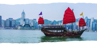Foto de fundo da página com barco local navegando pela baía, tendo a cidade de Hong Kong ao fundo envolta em névoa