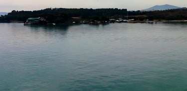 Foto tirada do convés mostrando a cidade de Vólos ao amanhecer, na chegada de navio.
