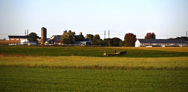 Amish farmer working the fields at evening with horses in Lancaster, Pennsylvania
