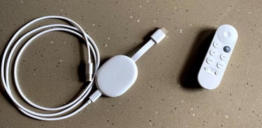 a remote control control and a white chromecast