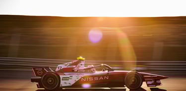 a man driving a Formula E race car on a track