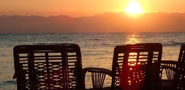Zonsopgang boven de Rode Zee met close-up van drie bamboe stoelen bij Bedouin Star, Ras Shitan