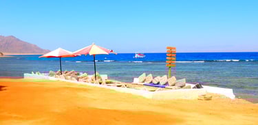 Strand-Sitzbereich im Bedouin Star Sinai: Blick auf das Rote Meer, Boot und ferne Mahash-Berge. 