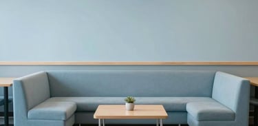 A minimalist reading area in a North American community center, with comfortable seating and pale blue decor promoting quiet reflection.