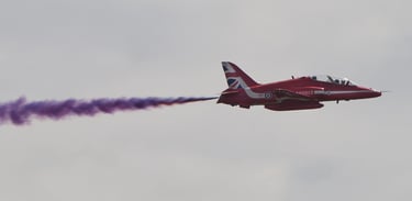 Close of up a Red Arrows plane with a trail of purple smoke at Goodwood Festival of Speed