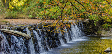 broad, and short waterfall at the dam of Ridley Creek State park, in the fall.