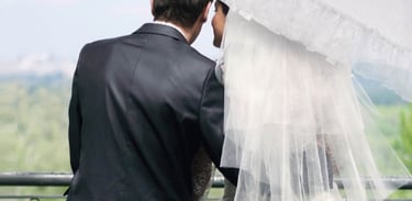 Married couple sitting together, the bride is holding an ornate doppler Manufaktur umbrella