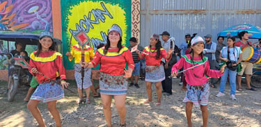 Indigenous Shipibo-Konibo women perform a traditional dance in colorful ethnic clothing during a cultural festival.