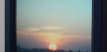 Close-up of a digital display showing a gentle sunset, representing peace and safety. North American aesthetic, clean lines, empathetic mood. Colors: Dark Navy and Light Aqua.
