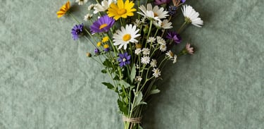 A high-angle photo of a clean, minimalist bouquet of wildflowers on a dusty green textile, representing simple beauty and hope.