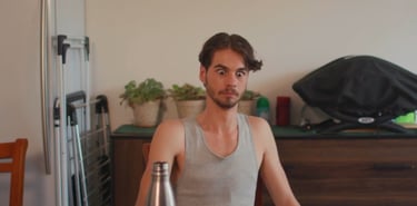 a man sitting at a table with a bottle of beer