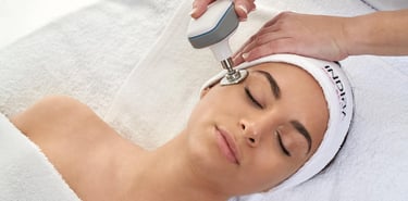 Un esteticista profesional realiza un tratamiento facial con INDIBA en la piel de una mujer