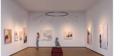 Iluminación técnica de galería con focos orientables sobre obras de arte