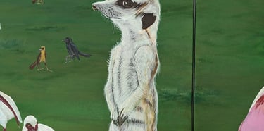 Acrylic painting of a female meerkat standing on a stump looking off into a field of wildlife.