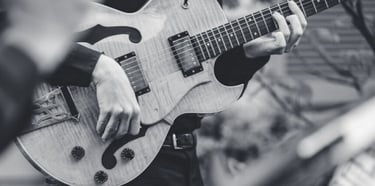 a black and white photo of a man playing guitar 
