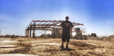 a man standing in front of a building under construction