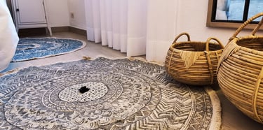 Alfombra redonda de tejido natural para el estudio de interiorismo de un dormitorio, realizado por IMPATTO interiorismo
