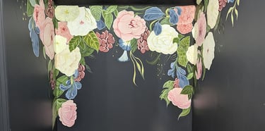 Half bath wall mural of draping and cascading flowers and foliage against a charcoal grey base wall.