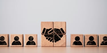 Wood Blocks Forming a Handshakre and with Outlines of People on Each Side 