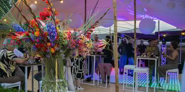 Elegant ingerichte feestzaal met tafels en partyverlichting en muziek.
