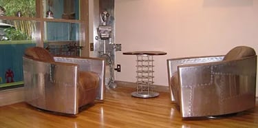 Living room with two aluminum and leather chairs and an aluminum table.