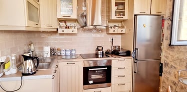 a kitchen with a refrigerator, stove, and a table
