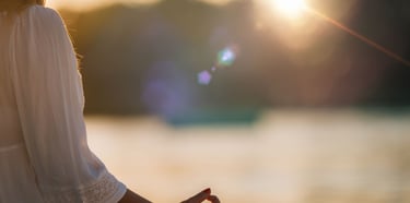 “Femme en méditation au bord de l’eau au coucher du soleil, posture de relaxation et bien-être.”