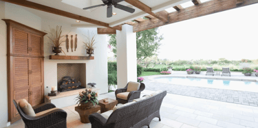 a patio with wicker furniture and a fireplace