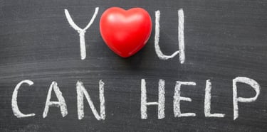 a red heart on a chalkboard with the words you can help