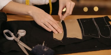 modista praparando una tela con el molde para cortarlo