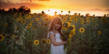 a girl in a white dress holding a bouquet of sunflowers