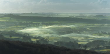 Rolling fog through cold green country fields