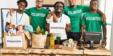 a group of people standing around a table with boxes of donations