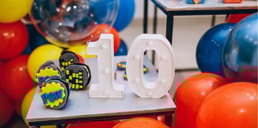une décoration d'anniversaire avec des ballons colorés et le chiffre 10 au centre