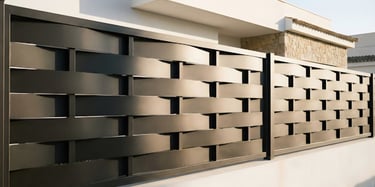 Valla metálica de lamas anchas entrelazadas Modelo Trenza instalada en vivienda unifamiliar