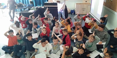 Une classe primaire qui fait le signe de reconnaissance du requin