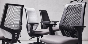 Row of T145 clerical chairs with perforated plastic backs in black and white finish