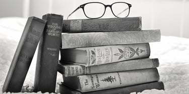 A stack of books with glasses on top of them representing educational translations