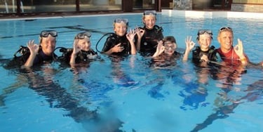 a group of people in scuba gear standing in a pool