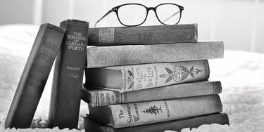 A stack of books with glasses on top of them representing educational translations