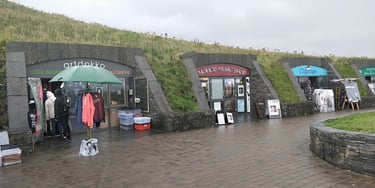 a group of people standing in front of a building at the cliffs of Moher