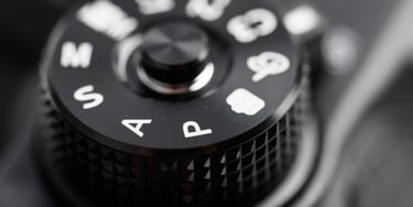 Close-up of a DSLR camera mode dial showing Auto (A), Program (P), settings, symbolising the choice between auto and manual