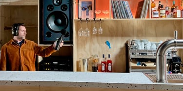 Un homme enregistre du son avec un sonomètre et un casque dans un bar